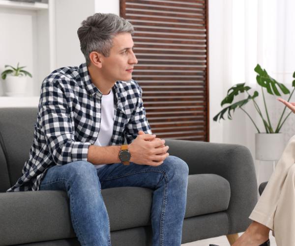 A man sits with a therapist to discuss detox and addiction rehab