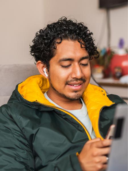 A young Hispanic man uses his mobile phone for an online therapy session