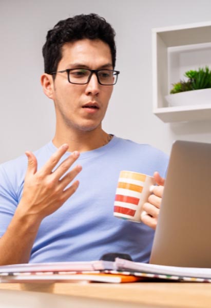 A man sitting at home, using his laptop for a web-based therapy program
