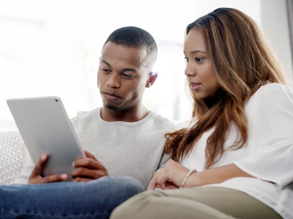 A couple sitting at a home and using a table for remote mental health and addiction therapy