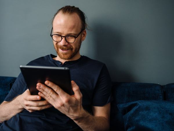 A man sitting at home using his table for a telemental health session
