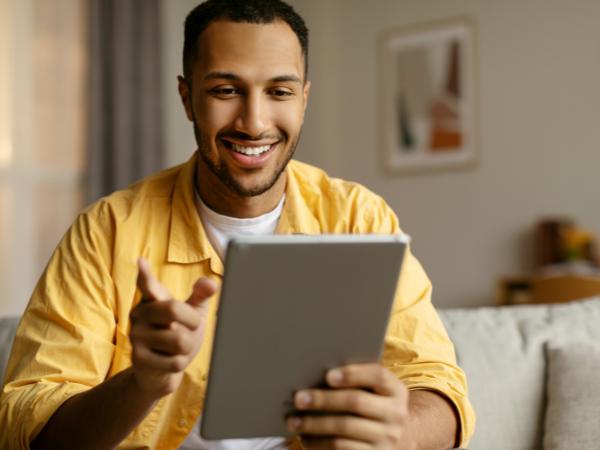 A man using a tablet at home for a web-based therapy session