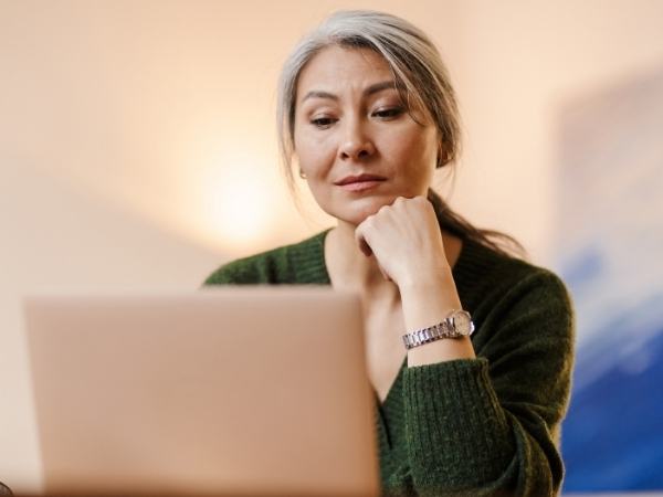A mature woman listens to her therapist during a remote therapy session