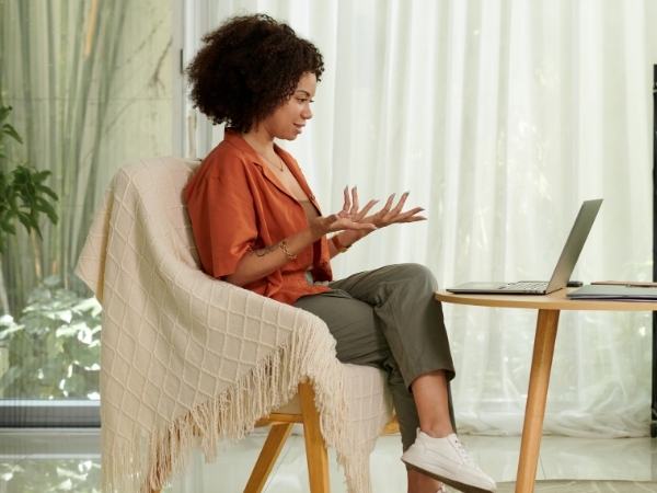 A woman uses her laptop at home for a remote therapy session