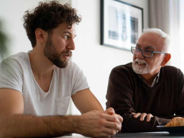 A senior father talks to his adult son in support of his rehab journey
