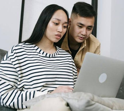A couple share a laptop for an online mental health session