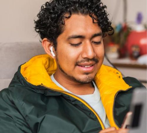 A young Hispanic man uses his mobile phone for an online therapy session