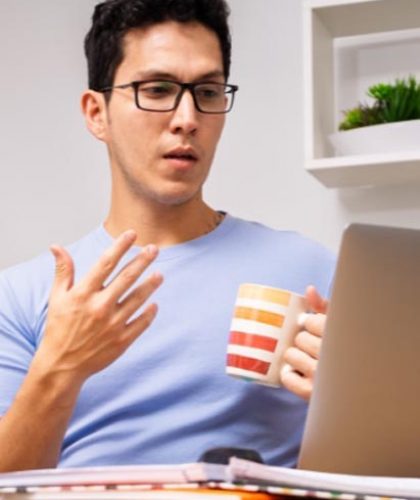 A man sitting at home, using his laptop for a web-based therapy program